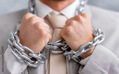 Businessman with Chains Around Neck and Hands, Concept of Restriction or Oppression