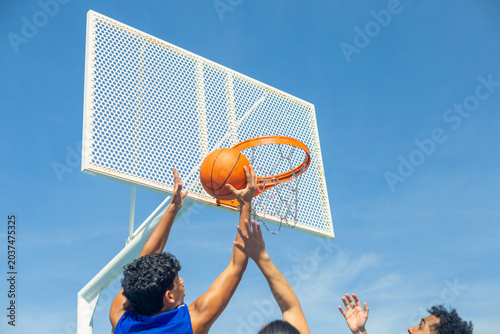 Tableau sur toile People playing basketball, scoring hoop outdoors