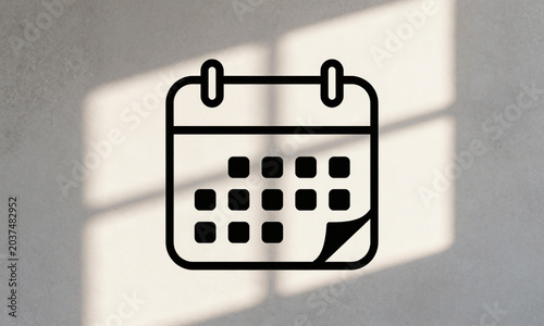 faded torn vintage calendar hangs askew rough textured concrete wall bathed warm soft glow late afternoon sunlight