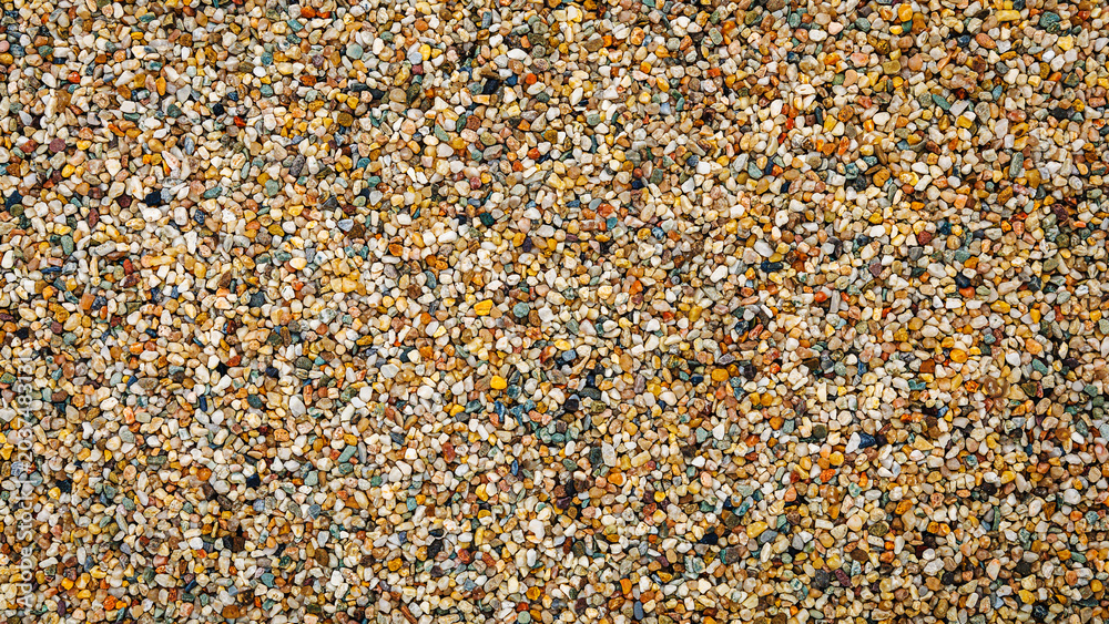 Fototapeta premium Various small stones and pebbles mixed together on the ground during daylight