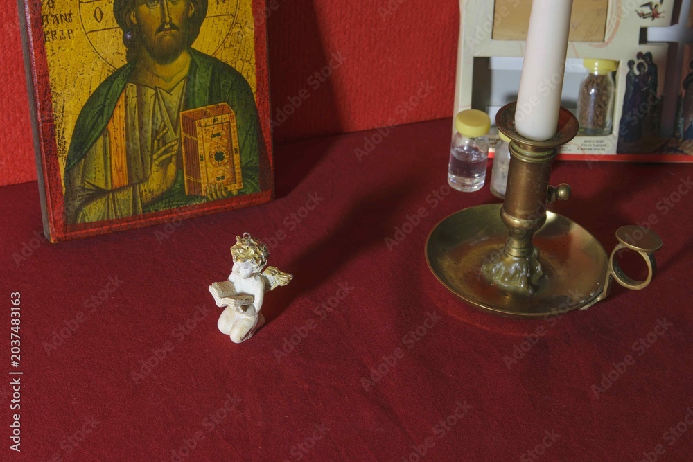 Obraz premium Various objects for prayer of the Christian faith Decorative statue with candle and icon on red tablecloth in a quiet room