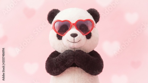 A soft cuddly panda stuffed toy holding a red heart and a pink flower makes a perfect fluffy teddy bear gift for childhood play