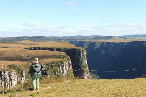 Pessoa observando o Canion Fortaleza, na Serra Geral, na cidade de Cambará do Sul que fica no estado do  Rio do Sul, no Brasil, dentro do Parque Nacional dos Aparados da Serra.