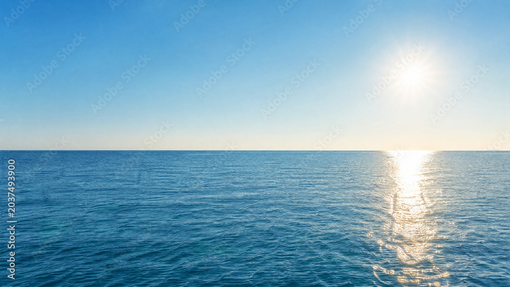 Obraz premium Blue Ocean Panorama With Sunlight Reflections. Beautiful Ocean Surface With Rippled Waves
