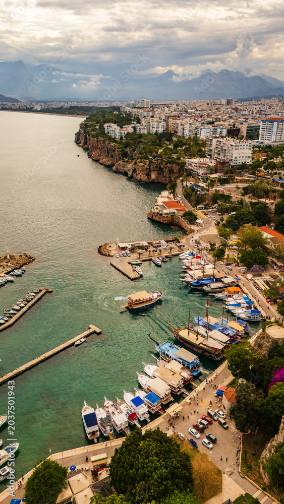 Fototapeta premium drone aerial Antalya Turkey old town Kaleici, showing the ancient Roman harbor, traditional red tiled roofs, steep cliffs