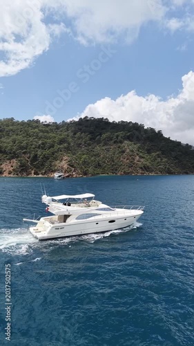 Elegant yacht cruising through crystal clear waters surrounded by greenery