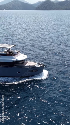 Sailing yacht glides across tranquil blue waters near lush green coastline
