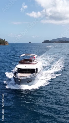 Sailing yacht glides across tranquil blue waters near lush green coastline