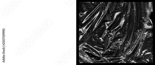 Crumpled plastic wrap texture on black background, wrinkled transparent cellophane film overlay, shiny distorted polyethylene material for design