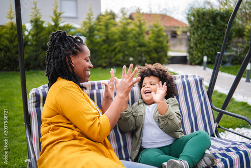 Tableau sur toile Mother and son playing games on swing