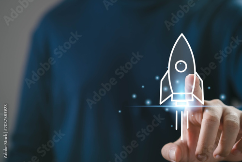 Obraz na plátně Startup launch concept with rocket icon on digital interface, man using smartphone, innovation growth strategy, business development, project success and technology startup acceleration idea