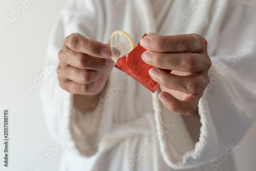 Canvastavla Woman holding a condom in her hands. The concept of safe sex.