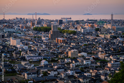 高台から望む夕暮れに染まる新居浜市の街並みと遠くの瀬戸内海に浮かぶ美しい島々（愛媛県）