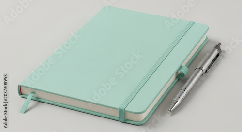 Mint green notebook with a pen on top, closed and ready for use