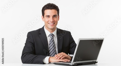 Smiling businessman in suit using laptop at desk