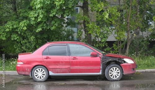 Canvastavla A red car with a broken right wing is parked near the lawn