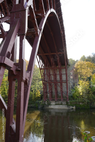 Detailed View Of The Historic Iron Bridge's Impressive Red Ironwork Spanning The River Severn In Ironbridge, Shropshire, England, On A Bright Autumn Day.