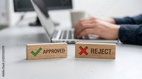 Approved vs Reject wooden blocks with person typing on laptop
