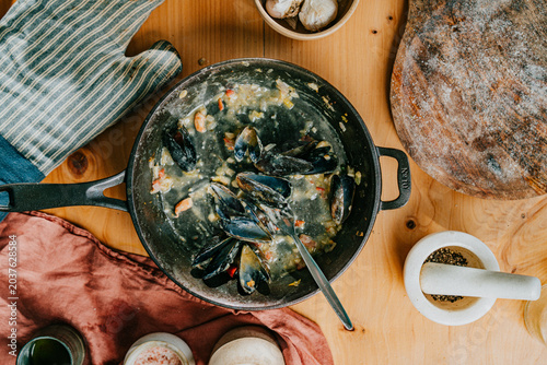 Foto Steaming mussels in cast iron skillet on wooden table