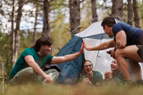 Cuadro en lienzo Friends enjoying a fun camping trip together in the forest, sharing laughter and