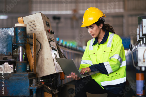 Female Industrial Worker Factory Operator Using Technology And Inspecting Manufacturing Equipment In Modern Metal Sheet Production Plant