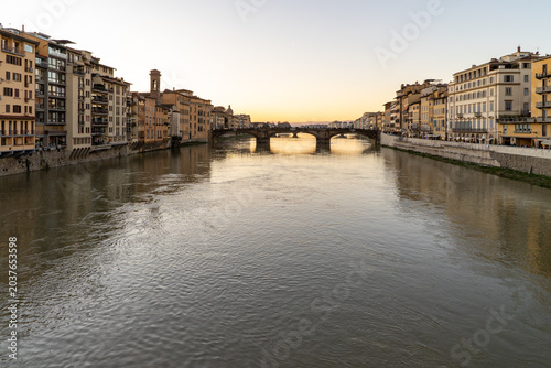 Tableau sur toile A wide view of the Arno River flowing through Florence with historic buildings l