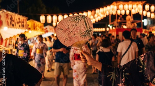 Gion Matsuri, a traditional Uchiwa fan held by a person in a silk Yukata, blurred festival crowd in the background with soft bokeh