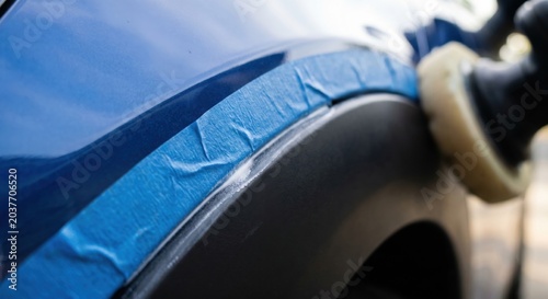 Blue masking tape protecting car trim during polishing