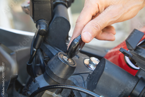 Inserting the key to start the motorcycle.