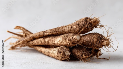 Fresh burdock roots on a clean white background in a minimalist still life