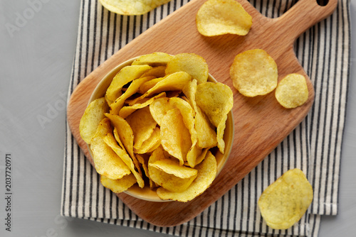 Cheese flavored potato chips in a bowl, top view.