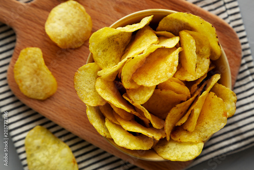 Cheese flavored potato chips in a bowl, top view.