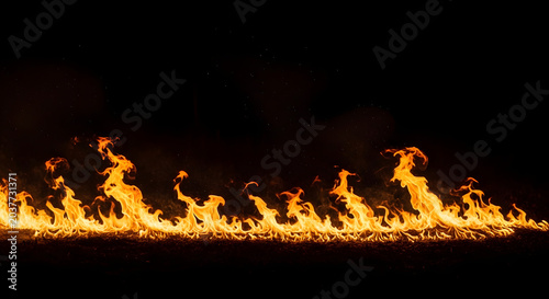 Dramatic flames burning intensely across a dark background with a fiery orange glow