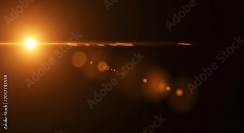 Golden lens flare with light streaks on a dark black background dramatic illumination effect