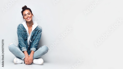 Woman smiling in denim jacket and jeans