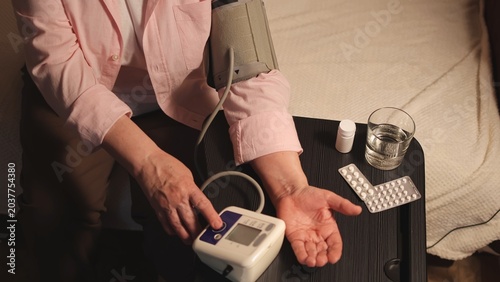 Elderly woman. Blood pressure monitor. Measure blood pressure. Sofa. High quality photo