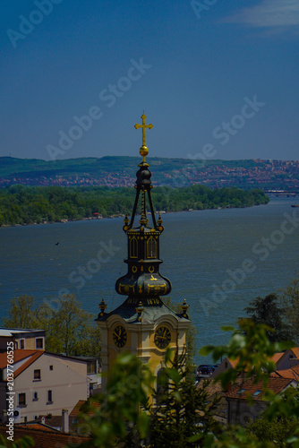beautiful view of the old green and yellow church tower and the rest of the city
