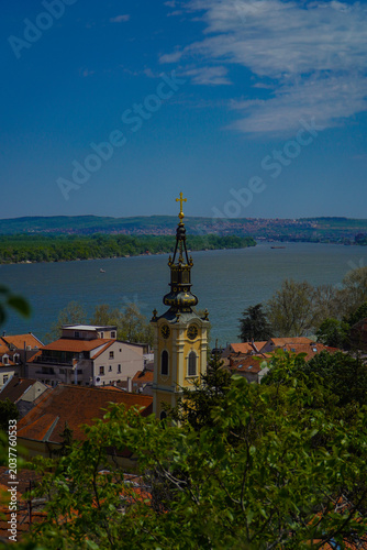 beautiful view of the old green and yellow church tower and the rest of the city