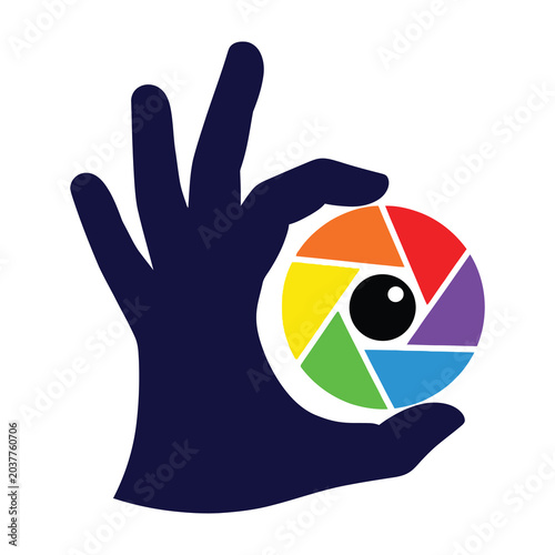 Hand Holding a Colorful Camera Lens Aperture Symbol for Creative Photography and Media Design