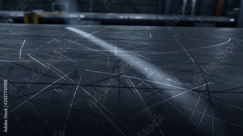 Light beam sweeping across a scratched industrial metal surface