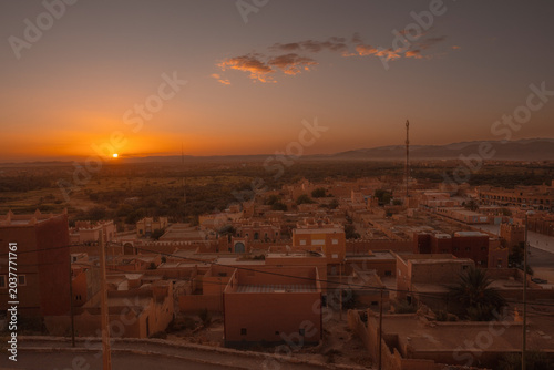 Golden sunrise illuminating the historic rofftops of desert city in Morocco.