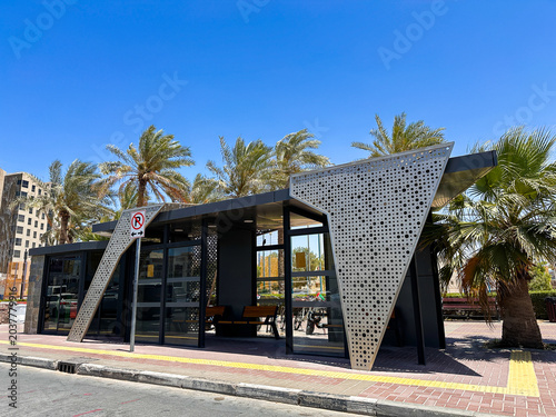Modern geometric glass and stone building facade with reflective windows in sunny urban setting