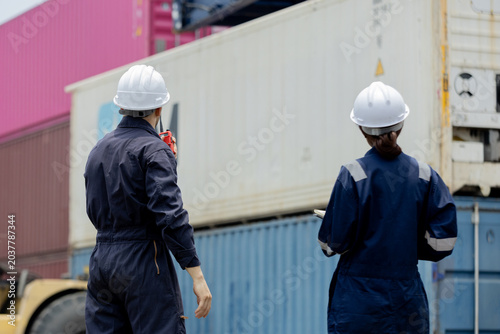 Εκτύπωση καμβά Two workers in safety gear oversee cargo containers at a shipping yard, highlighting logistics and industrial operations