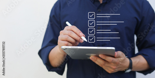 close up businessman hand use stylus to check online questionnaire survey from website to rate score and share aspect of audience after complete from seminar for business corporation concept