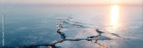 Cracked Ice Surface Reflecting Golden Sunset Light Across Calm Water Horizon
