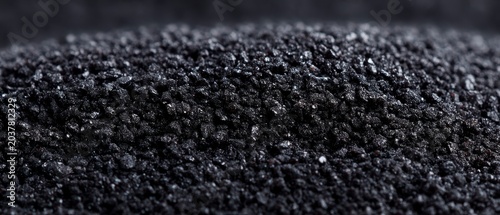 Close Up of Dark Glittery Sand with Reflective Particles Under Soft Lighting