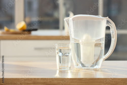 Bilde på lerret Water filter pitcher and glass on  kitchen table