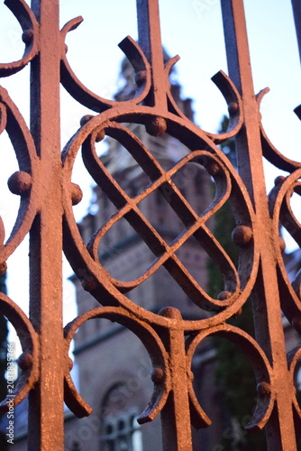 Tableau sur toile Wrought iron fence pattern with blurred historical building of Chernivtsi Univer
