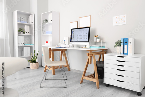 Interior of medical office with doctor's workplace and shelf units