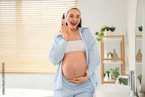 Young pregnant woman cleani...